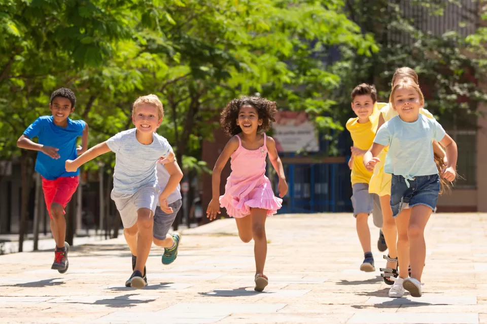 Group of children running outdoors toward camera.
